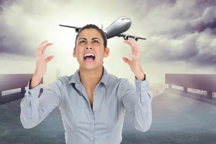 A stock photo of a woman in agony in front of an airplane